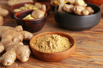 Fresh and ground ginger on wooden table