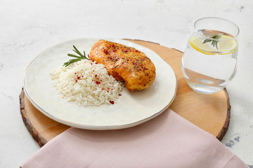 Plate with tasty rice and chicken on white background