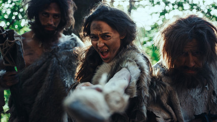 Female Leader and Two Primeval Cavemen Warriors Threat Enemy with Stone Tipped Spear, Scream,...
