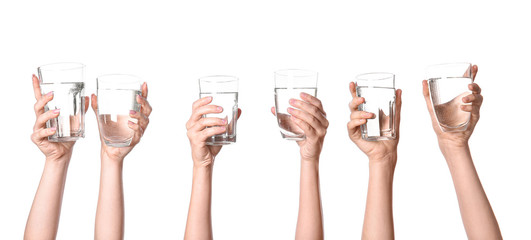 Female hands with glasses of water on white background
