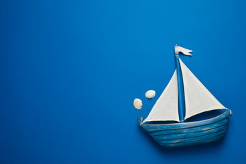 Toy ship on bright background, top view with space for text. Color of the year 2020 (Classic blue)