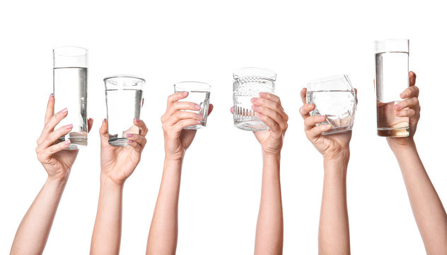Female hands with glasses of water on white background