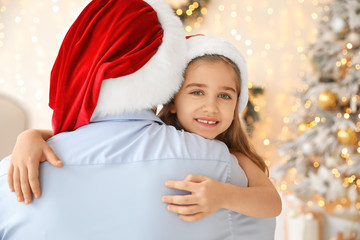 Father with little daughter on Christmas eve at home