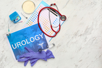 Paper sheet with text UROLOGY, medicines, gloves and stethoscope on light background