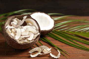 Tasty coconut chips on wooden table. Space for text