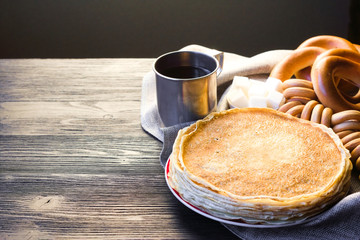 Shrovetide Maslenitsa festival. Table with pancakes (blini), bagels (sushki and baranki) and tea.