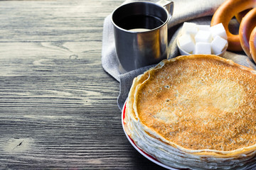 Shrovetide Maslenitsa festival. Table with pancakes (blini), bagels (sushki and baranki) and tea.