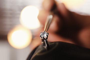 Professional jeweler working with beautiful ring indoors, closeup