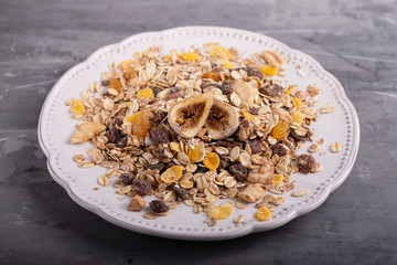 muesli with nuts and dry figs on dish on ceramic background