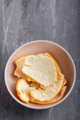 orange peel in small bowl on ceramic background