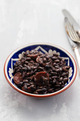 Fototapeta na wymiar black beans with smoked sausages in ceramic dish