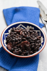 black beans with smoked sausages in ceramic dish