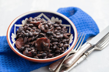 black beans with smoked sausages in ceramic dish