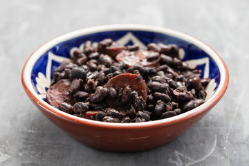 black beans with smoked sausages in ceramic dish