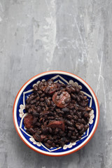 black beans with smoked sausages in ceramic dish