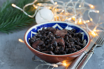 black beans with smoked sausages in ceramic dish