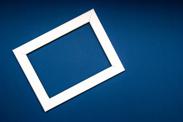 White photo frame on a blue background. Space for text, copy space.