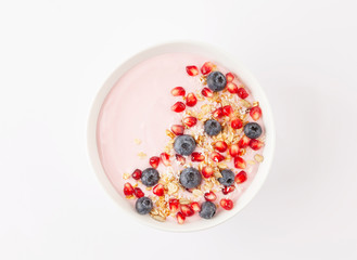 Breakfast smoothie bowl with yogurt, granola, blueberries, pomegranate seeds and shredded coconut. Healthy breakfast. Top view. 