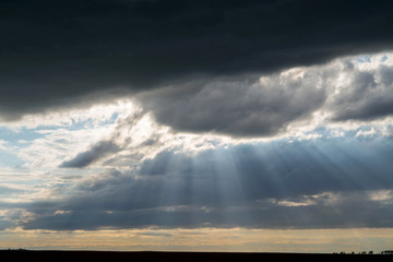Beautiful landscape at sunset.Rays of sunlight break through the menacing dark clouds, after a summer rain.