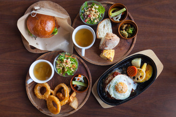 Homemade onion rings, Hamburger with Egg Lettuce and Tomato. hamburger beef steak grill bread with rocket salad tomato fried egg, black pepper seed on wooden plate, selective focus. chips and tea.