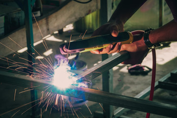 Fototapeta premium Industrial Worker labourer at the factory welding steel structure, Welder at work