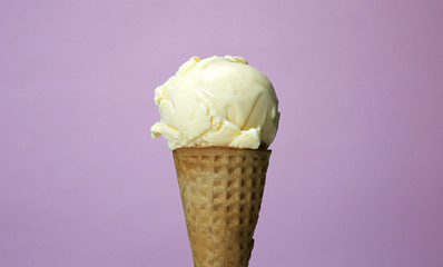 Ice cream flavoured vanilla in waffle cone isolated on pink background, Closeup Front view Food concept..