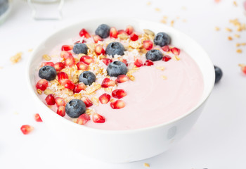 Smoothie bowl with yogurt, granola, blueberries, pomegranate seeds and shredded coconut. Healthy breakfast.