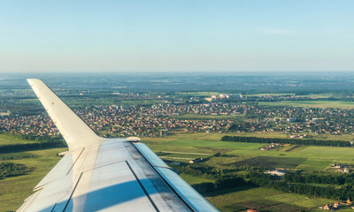 Suburb of a large European city through the porthole of an airplane