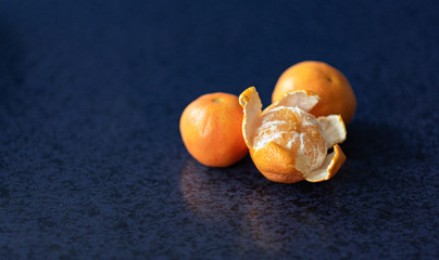 Obraz premium Mandarin oranges closeup on dark background, riped mandarine orange