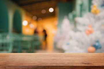 Empty wood table top on blur with bokeh Christmas tree and new's year decoration on window background - can be used for display or montage your products.