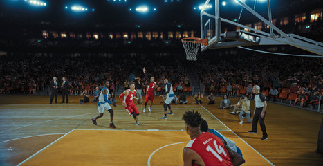 Basketball players on big professional arena during the game. Tense moment of the game. Celebration