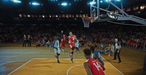 Basketball players on big professional arena during the game. Tense moment of the game. Celebration