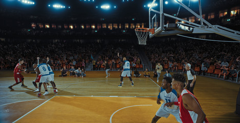 Basketball players on big professional arena during the game. Tense moment of the game. Celebration
