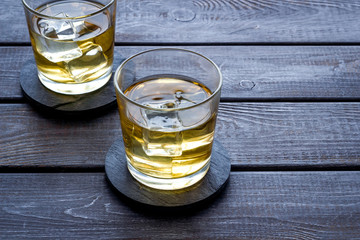 Scotch - two glasses with ice - on dark wooden background copy space