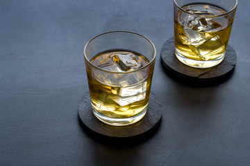 Scotch - two glasses with ice - on black background copy space