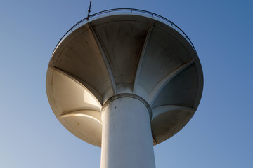 Fototapeta na wymiar round concrete tower on a background of blue sky 