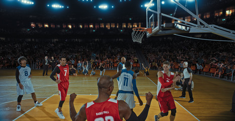 Basketball players on big professional arena during the game. Tense moment of the game. Celebration