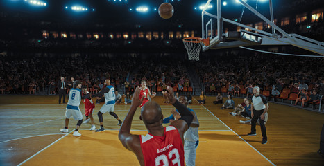 Basketball players on big professional arena during the game. Tense moment of the game. Celebration