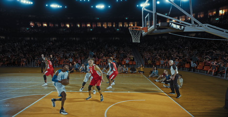 Basketball players on big professional arena during the game. Tense moment of the game. Celebration