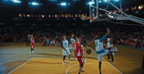 Basketball players on big professional arena during the game. Tense moment of the game. Celebration