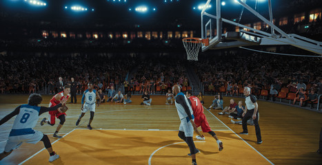 Basketball players on big professional arena during the game. Tense moment of the game. Celebration