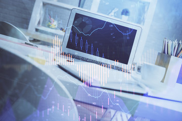 Stock market chart hologram drawn on personal computer background. Double exposure. Concept of investment.