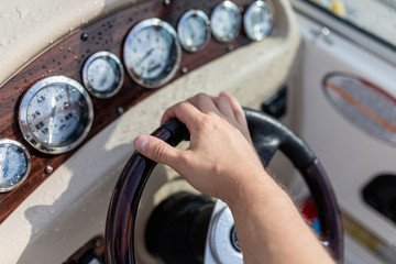 Male hand control the direction of the ship, force the direction of the yacht with the right hand,...