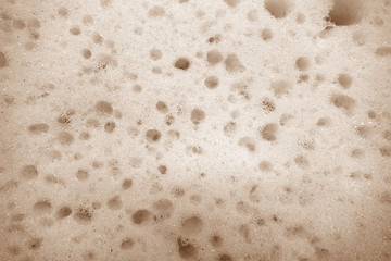 Cleaning sponge surface close up in brown color.