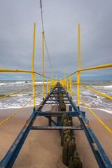 Yellow jetty and Baltic Sea on a cloudy day. Jaroslawiec, a fishing village in Poland