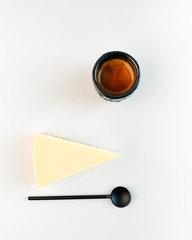 Coffee espresso in a black cup with a black spoon and cheesecake