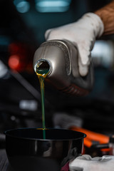 cropped view of mechanic pouring lube oil in funnel