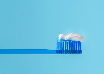 Fototapeta na wymiar Toothbrush and paste on a blue back round. Closeup.