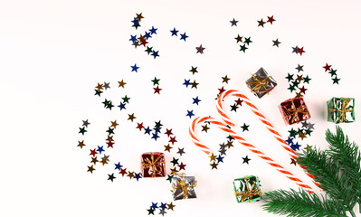 White christmas background. Decorative multi-colored stars. Christmas decorations. Spruce branch. Top view.