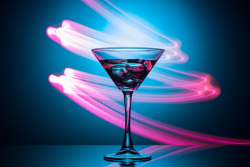 Martini glass with drink and ice, with a spectacular illumination of the background.